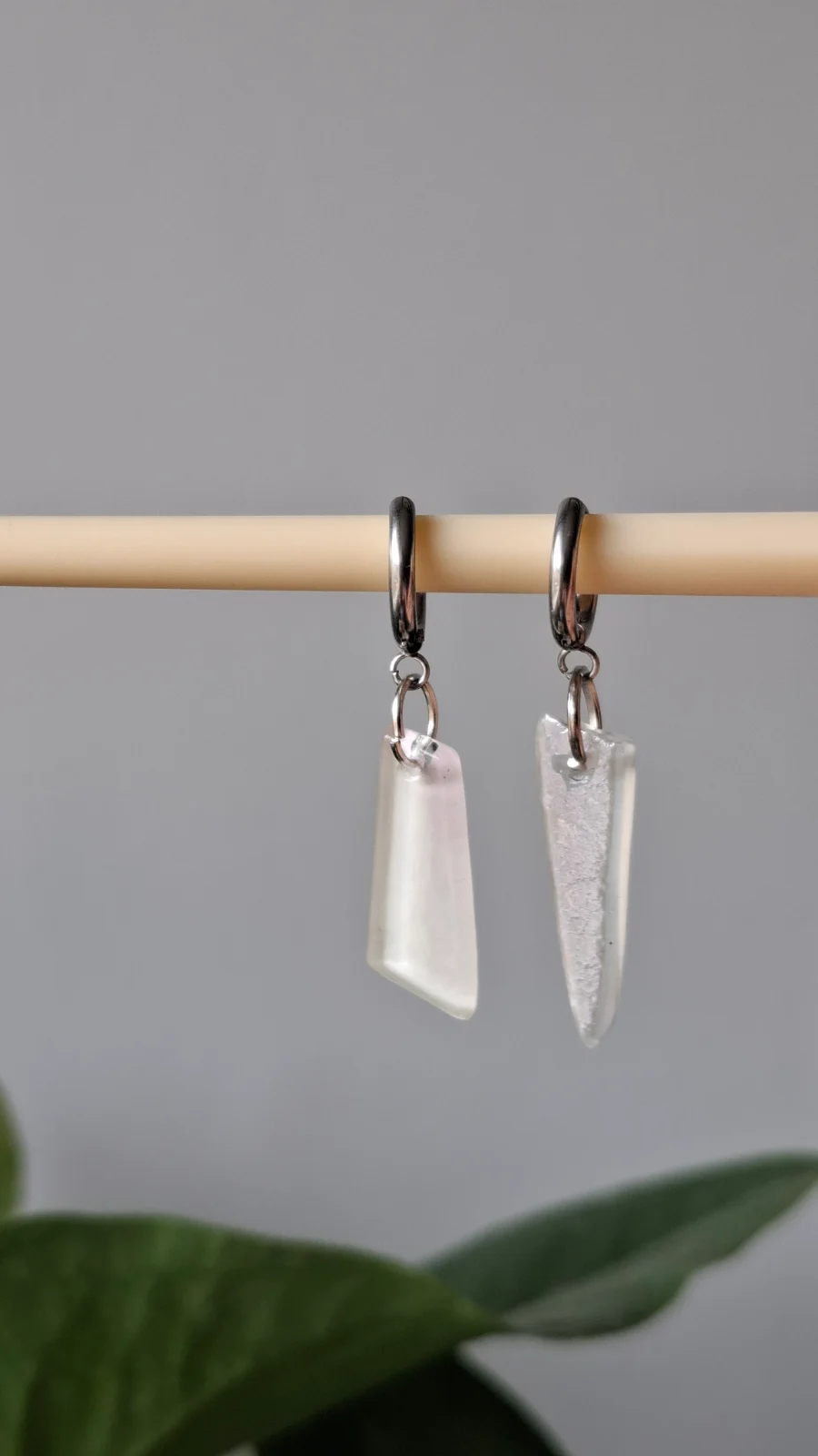 Paire de boucles d'oreilles asymétriques en verre blanc laiteux suspendues à une tige
