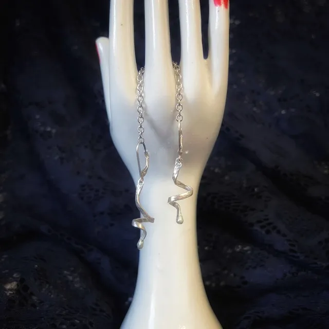 Gros plan sur les boucles d'oreilles torsadées en argent 925 avec attaches dormeuses