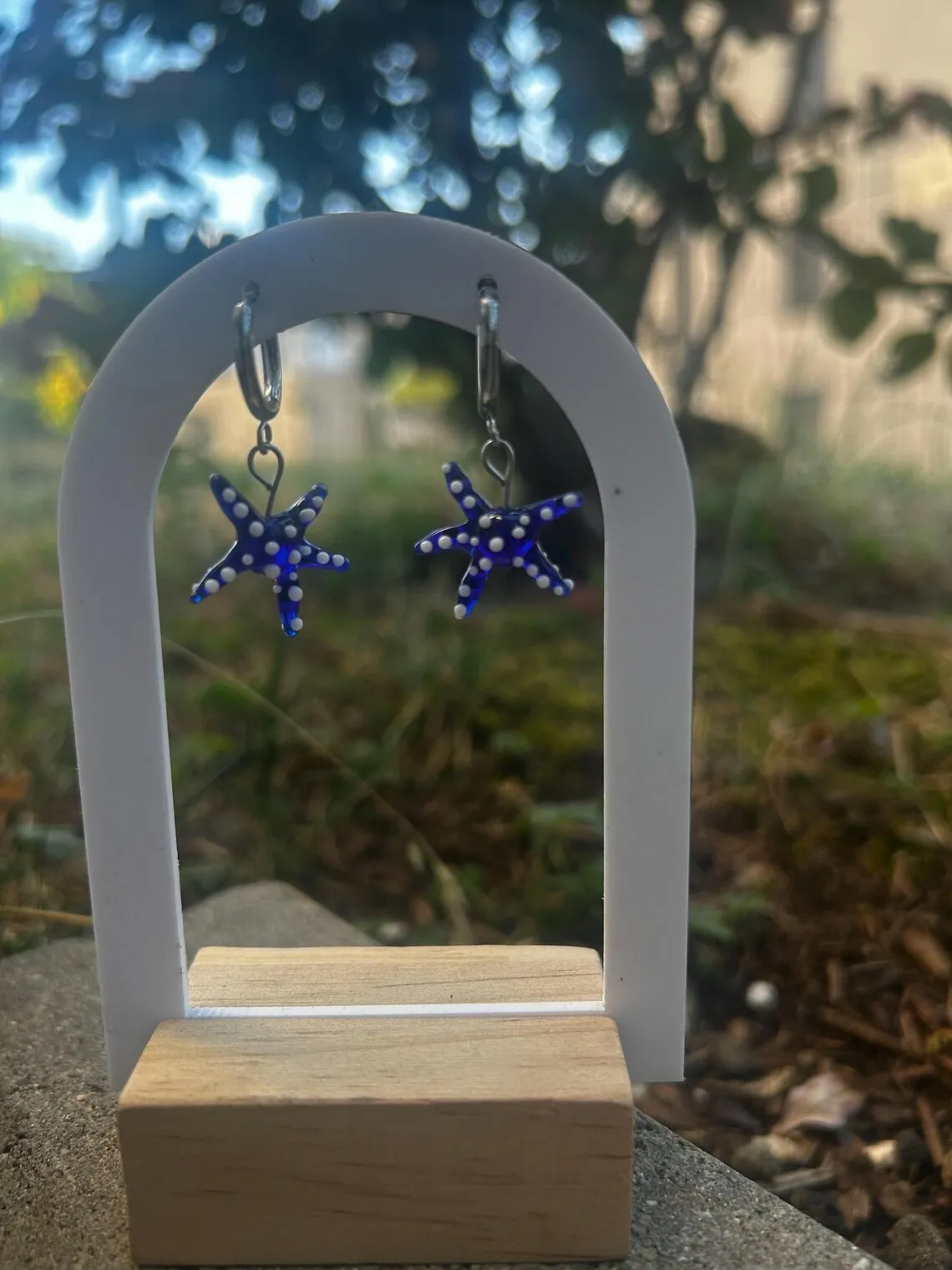 Paire de boucles d'oreilles pendantes étoiles de mer bleues suspendues sur un support en arche