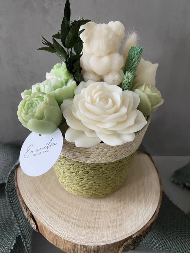Pot tressé vert et écru garni de fleurs parfumées sculptées et d'un petit ours blanc